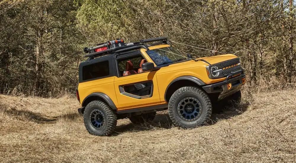 A yellow 2021 Ford Bronco is parked off-road.