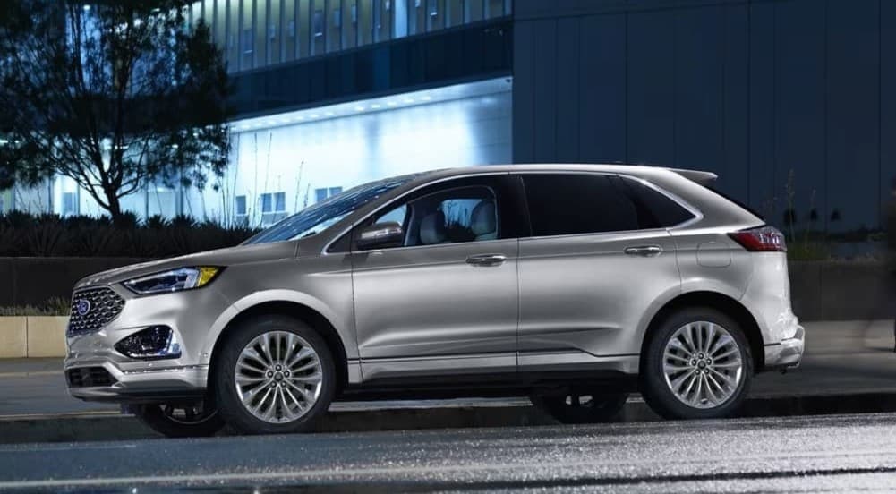A silver 2024 Ford Edge parked in a city.