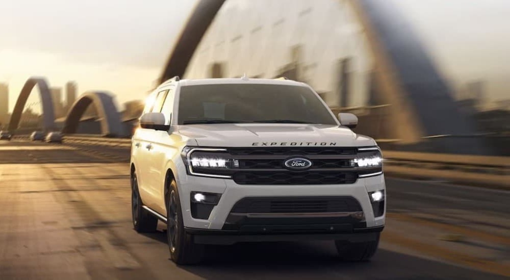 A white 2024 Ford Expedition driving to view a used Ford for sale.