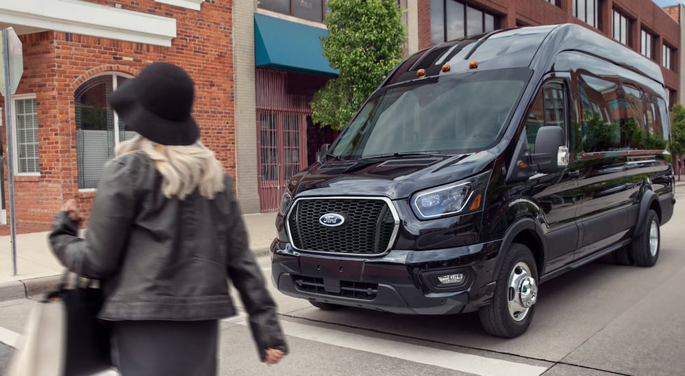 Black 2026 Ford Transit Van stopped at an intersection.