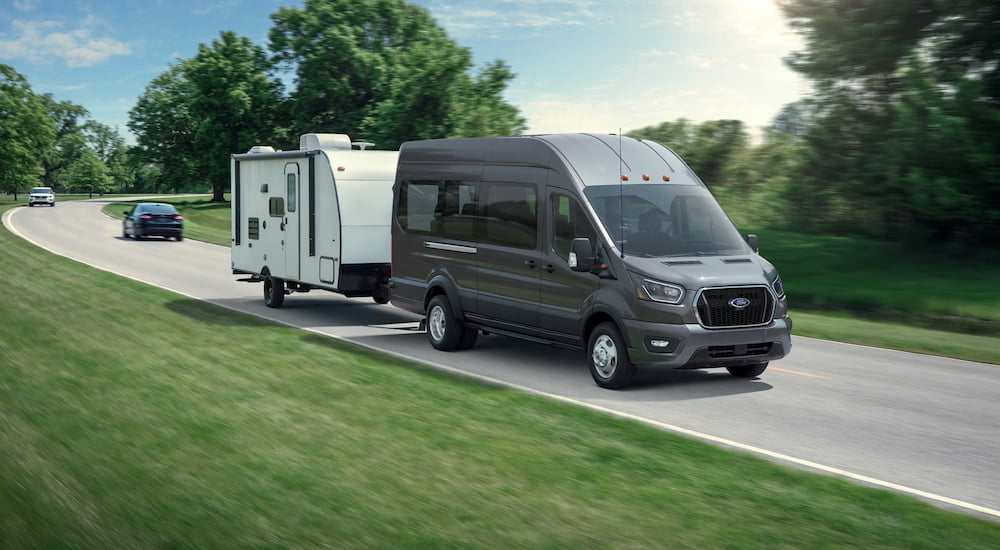 Grey 2026 Ford Transit Van towing a trailer.