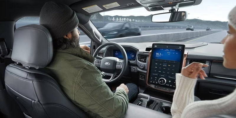Detail of driver and passenger using Ford F-150 Lightning interior infotainment interface
