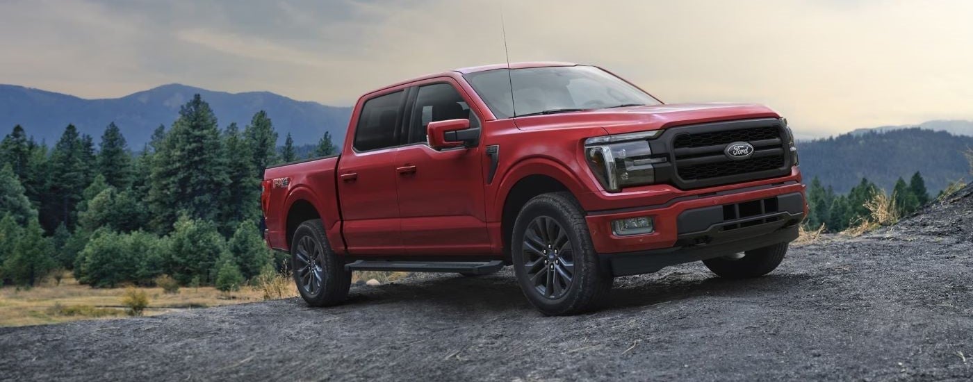A red 2024 Ford F-150 Lariat parked offroad.