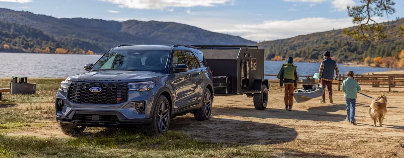 Grey 2025 Ford Explorer ST towing a trailer off-road.