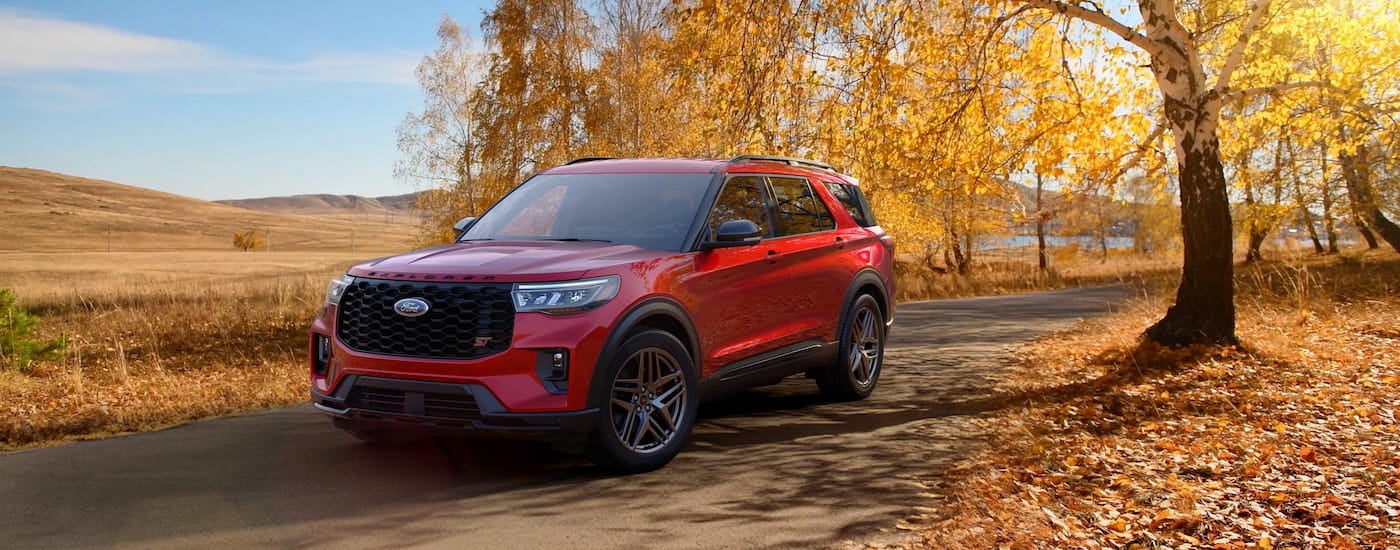 Red 2026 Ford Explorer ST driving down an open road.