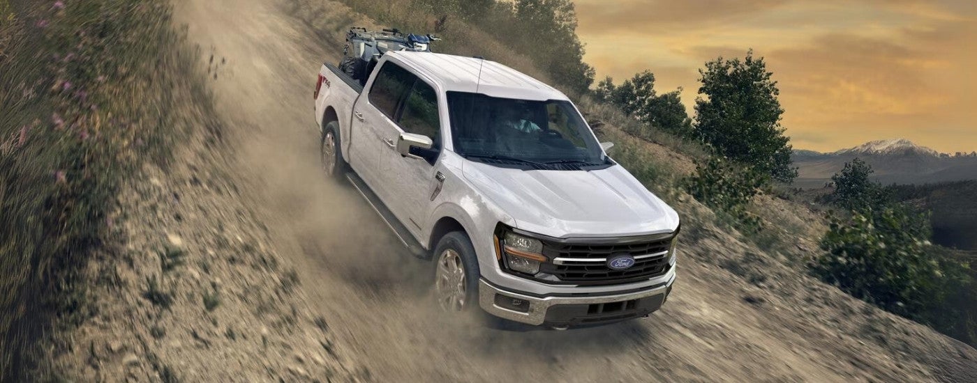 White 2025 Ford F-150 XLT driving down a hill