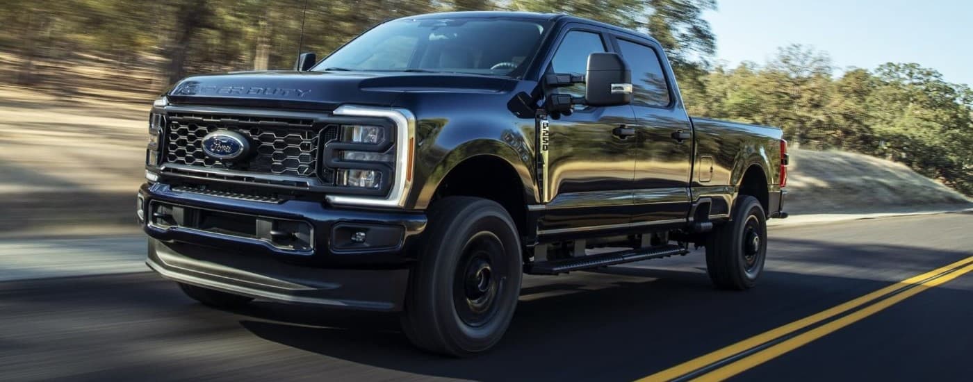 Black 2026 Ford F-250 XL STX driving down an open road.