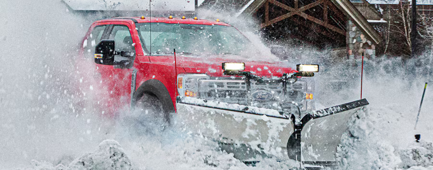 Red 2025 Ford F-450 plowing snow