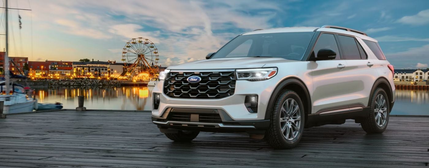 Silver 2026 Ford Explorer with an amusement park in the background.