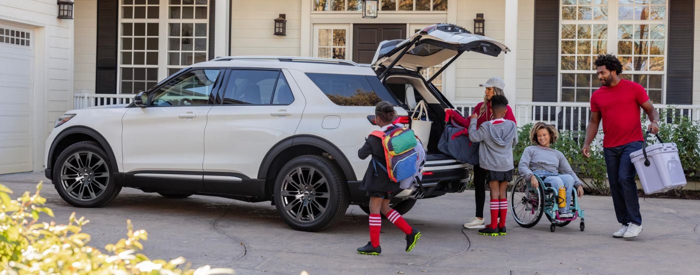 White 2026 Ford Explorer in a driveway with a family.