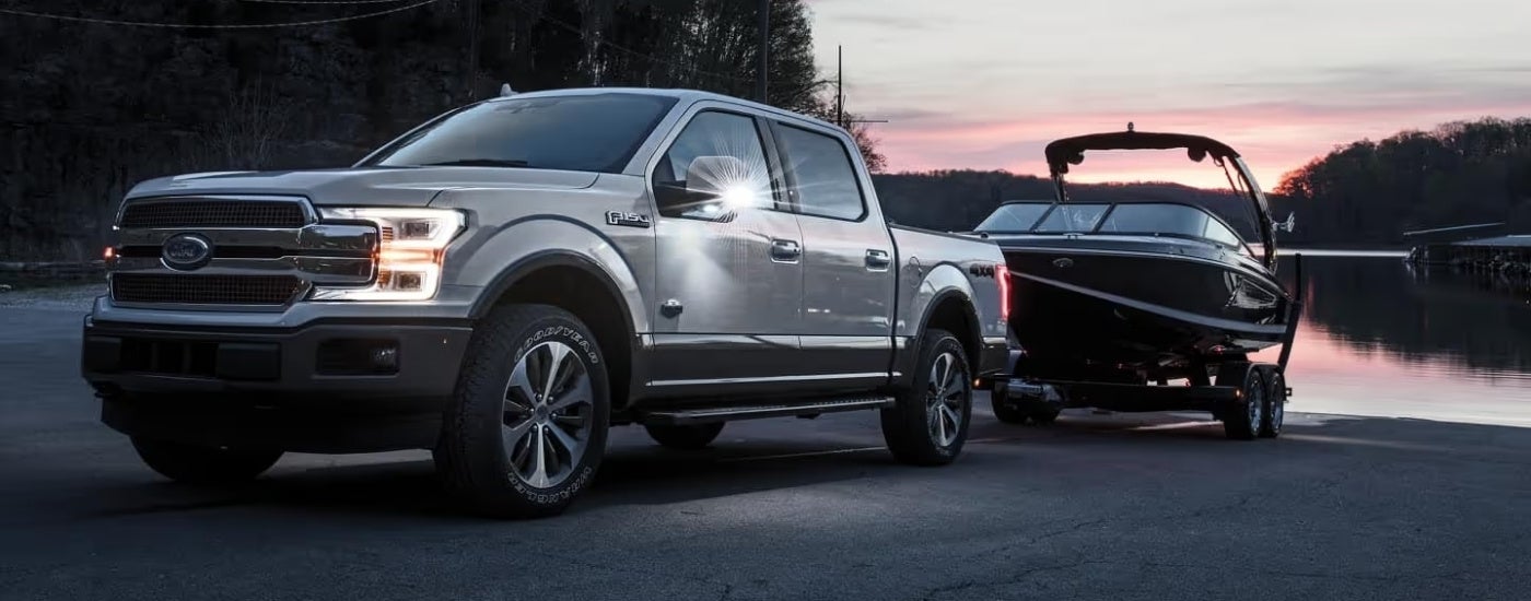 A grey 2018 Ford F-150 King Ranch towing a boat.