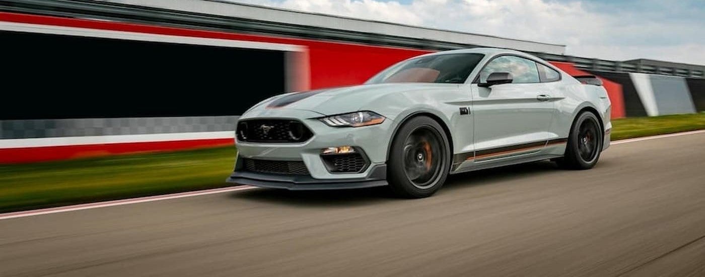 A gray 2023 Ford Mustang Mach-1 driving on a track.