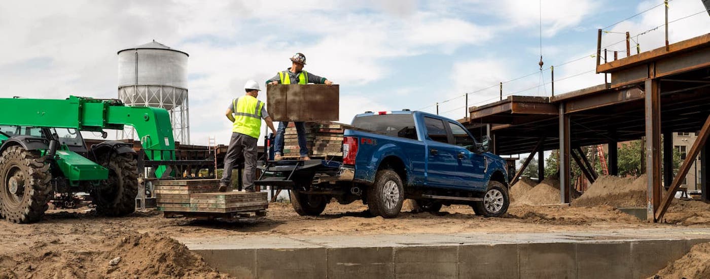 Rear of a blue 2020 Ford F-250 parked at a construction site.